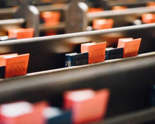 church pews with orange hymnals