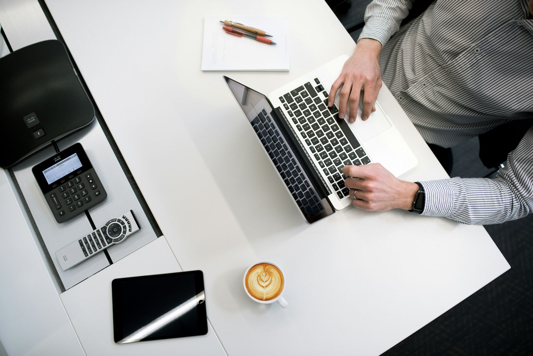 a person using a laptop at a desk looking for side income